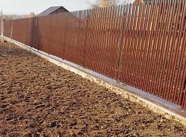 Забор на бетонном фундаменте с металлическим штакетником